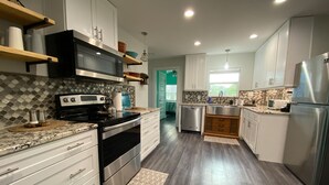 Una cocina moderna con electrodomésticos de acero inoxidable, gabinetes blancos y un salpicadero con diseño.