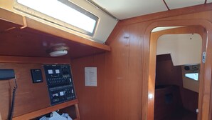 Une cabine compacte avec un intérieur en bois, un panneau de commande et une petite fenêtre.