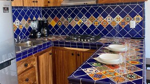 A kitchen with wooden cabinets, a microwave, a Samsung refrigerator, and a colorful tiled backsplash. - A/C WIFI Zona Romantica Private Balcony Roof Top/Pool 5 Blocks from the beach (Puerto Vallarta)