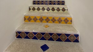 A staircase with patterned tiles and a metal handrail. - A/C WIFI Zona Romantica Private Balcony Roof Top/Pool 5 Blocks from the beach (Puerto Vallarta)
