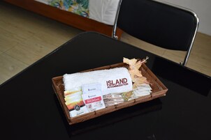 Una bandeja de madera con una toalla blanca, una pluma y alimentos para el desayuno sobre una mesa negra.
