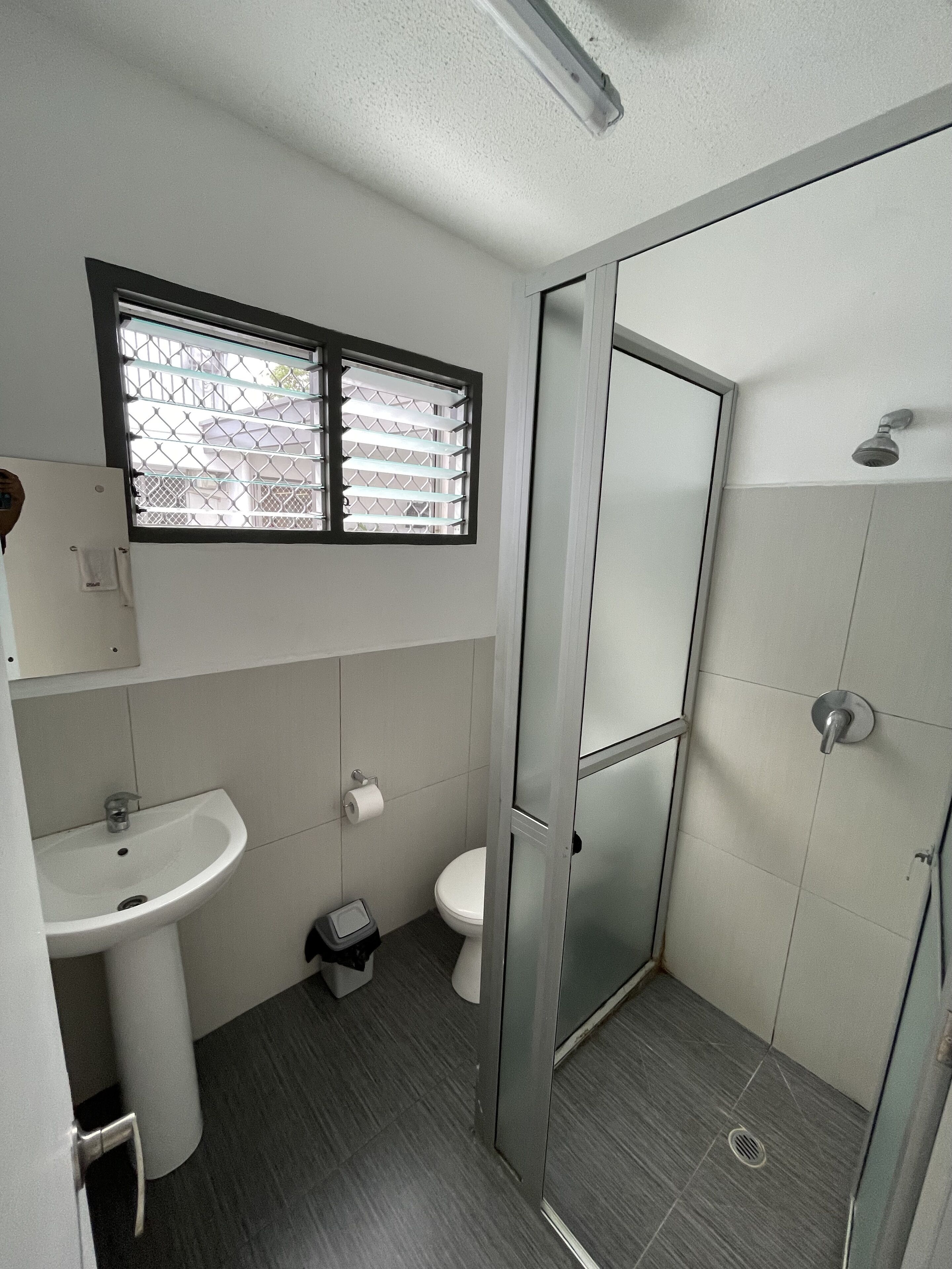 A modern bathroom with a sink, toilet, and glass shower enclosure.