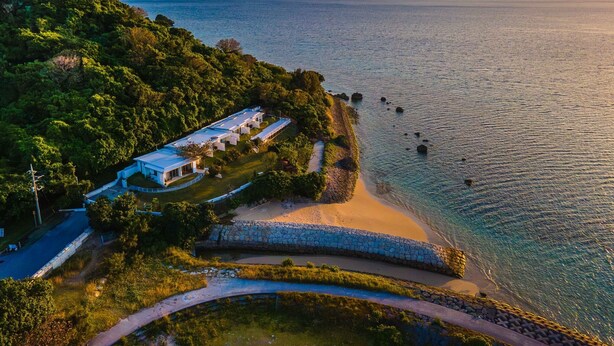 A coastal property with a white building, a stone pathway, and a view of the sea. - 413 Hamahiga Hotel&cafe (Uruma)