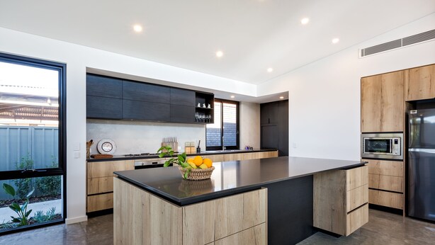 A modern kitchen with a large island, dark cabinetry, and stainless steel appliances. - Chesters by the Bay: luxury family home, walk to beach and town (Dunsborough)