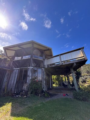Une structure rustique en bois, dotée d’une grande fenêtre et d’un porche abrité.