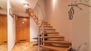 A wooden staircase with a handrail, a door with a 'Private' sign, and a small rug on the floor. - Ferienhaus Ivory, Deutschland (Binz)