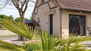 Een huis met een bruin pannendak, een zichtbaar raam en een deur.