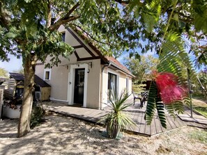 Una casa con terraza de madera, una puerta y una ventana.