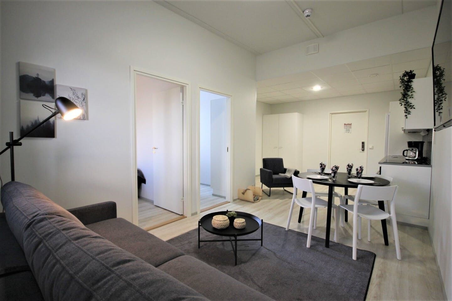 A modern apartment with a living room, dining area, and kitchenette.