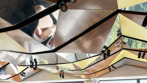A modern lounge area with large windows, geometric ceiling design, and comfortable seating. - Premier Hotel Odesa (Odesa)