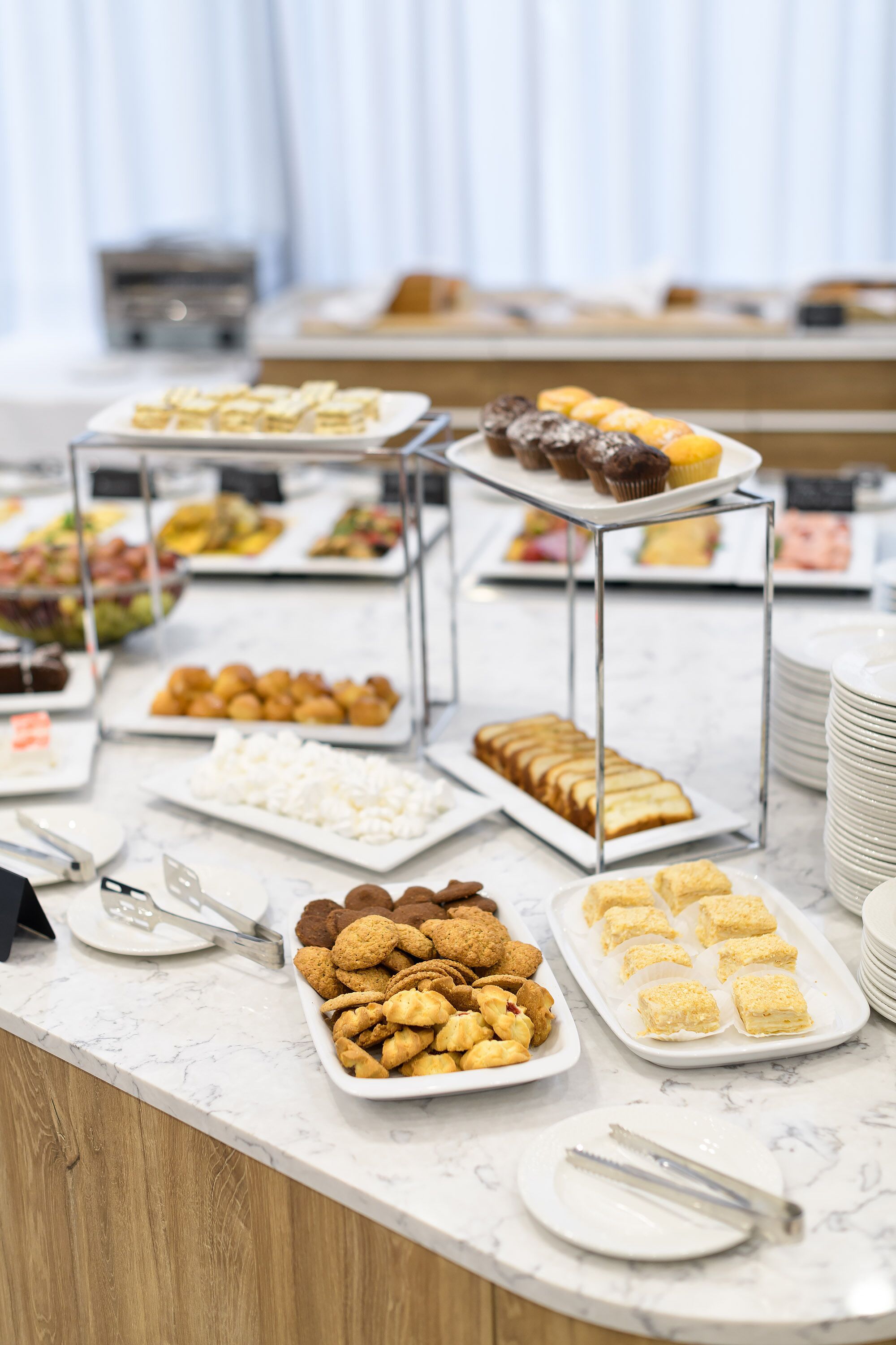 Een buffet met diverse gerechten, waaronder gebak, koekjes en desserts.