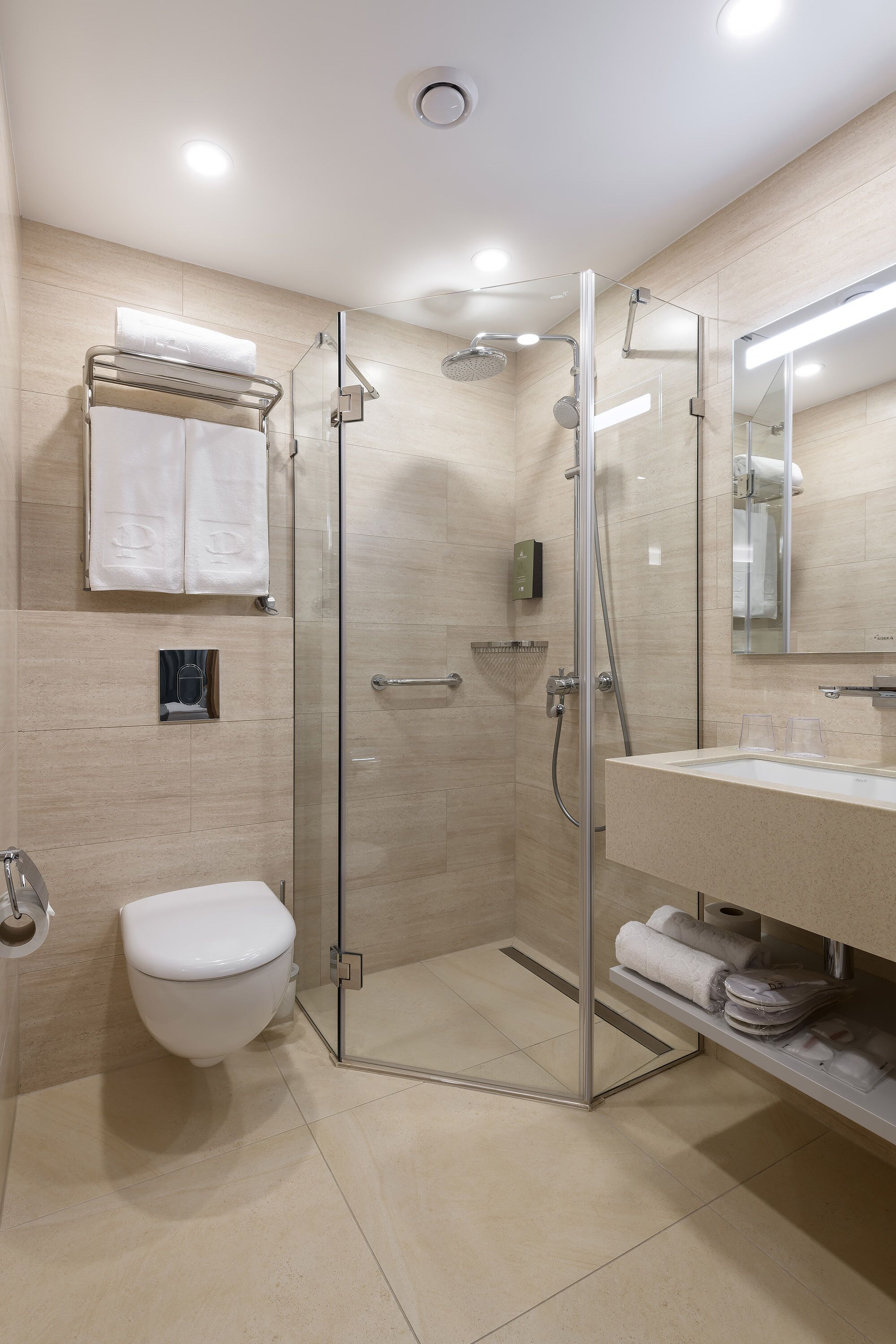 Une salle de bain moderne avec une douche à parois de verre, des toilettes et un lavabo avec un miroir.
