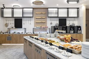 Een moderne keuken met een centraal eiland, ingebouwde apparatuur en diverse etenswaren op het aanrecht.