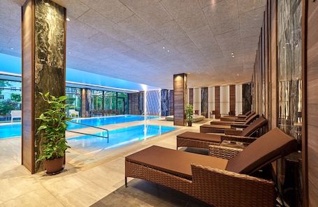 Una piscina techada, sillones reclinables de piscina