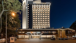 A tall hotel building with a prominent sign at the top and a well-lit entrance. - Premier Hotel Odesa (Odesa)