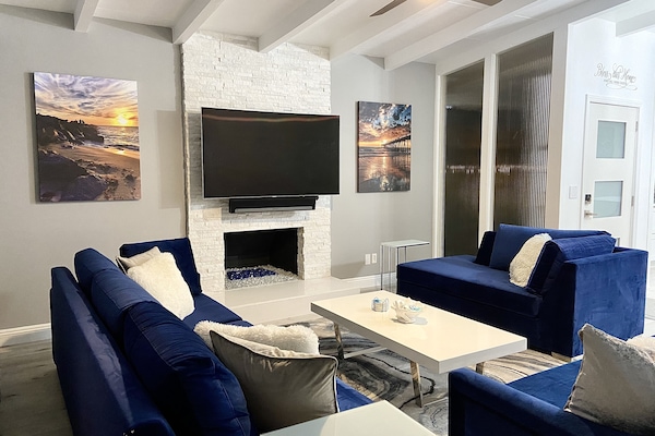 Living room w/ fireplace, ceiling fan, 65" curve TV w/ Sonos soundbar and Roku