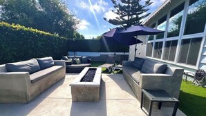 Eine Außenpatio mit einem Feuerkorb, zwei Sofas und einem kleinen Tisch.