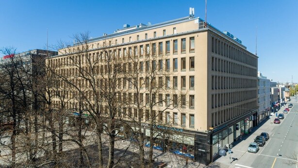 Un immeuble à plusieurs étages, doté d’une façade symétrique, de grandes fenêtres et d’un toit plat.