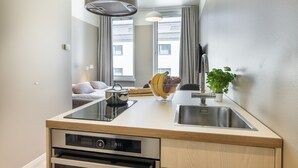 Une cuisine compacte dotée d’un four encastré, d’un évier et d’un petit plan de travail.