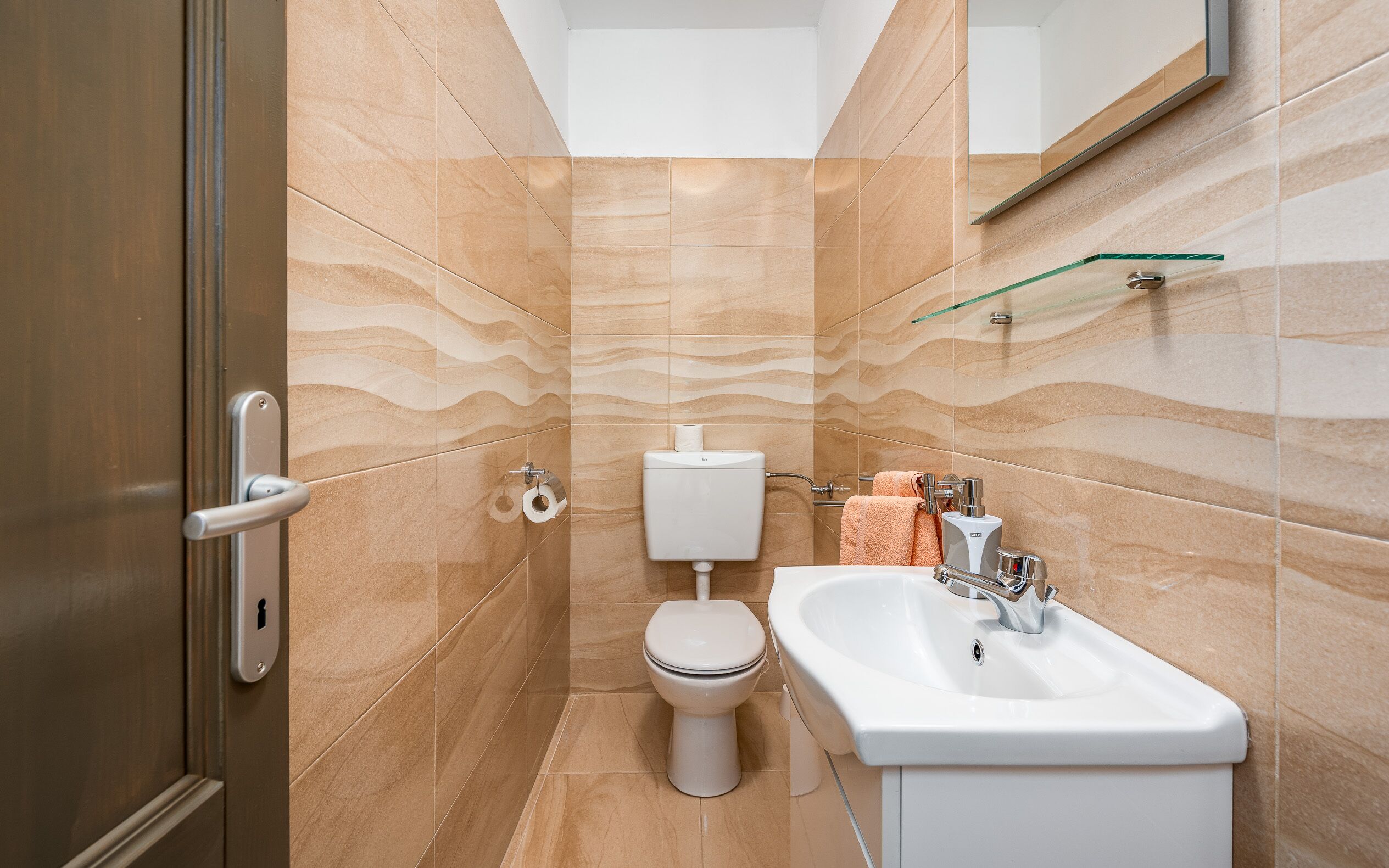 Ein Badezimmer mit Toilette, Waschbecken und Handtuchhalter.
