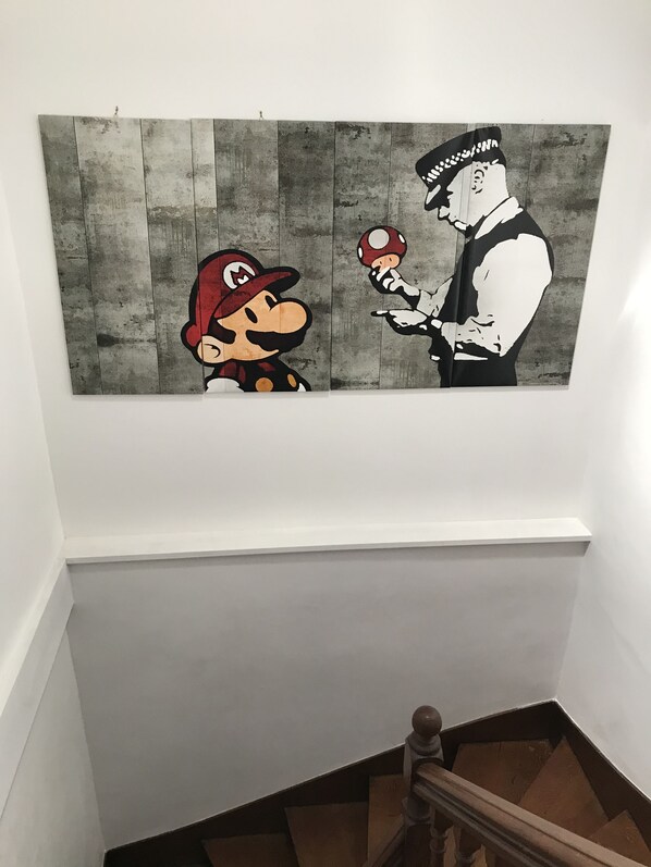 Una obra de arte montada en la pared que muestra a dos personajes de un videojuego popular, sobre un fondo gris con textura.