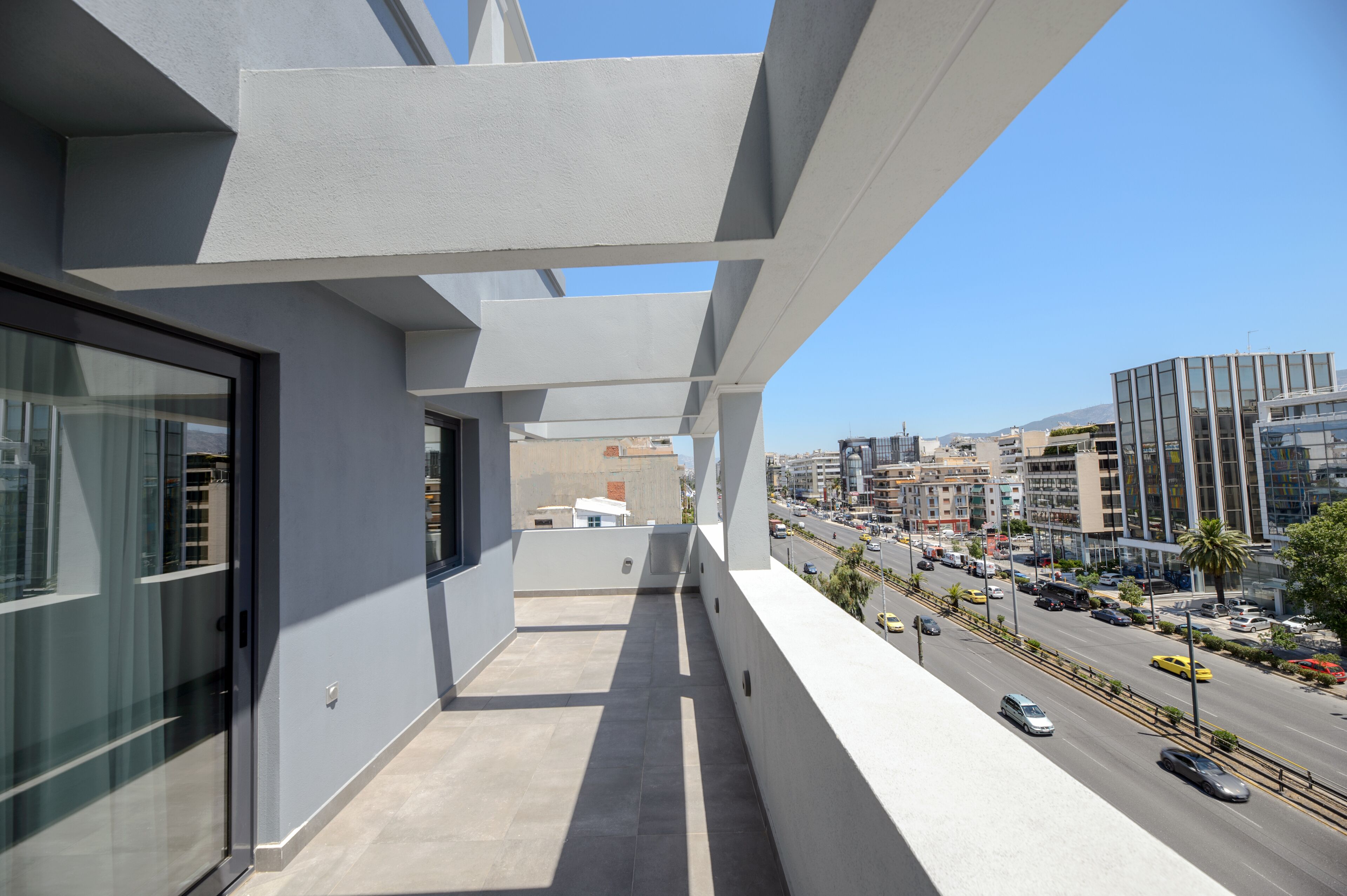 Un balcón con vista a la ciudad, arquitectura moderna y cielo despejado.