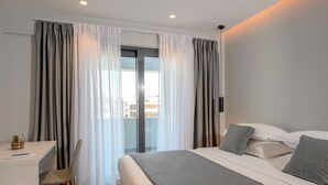A modern hotel room with a bed, a desk, and a chair. - The Convo Syngrou Apartments (Kallithea)