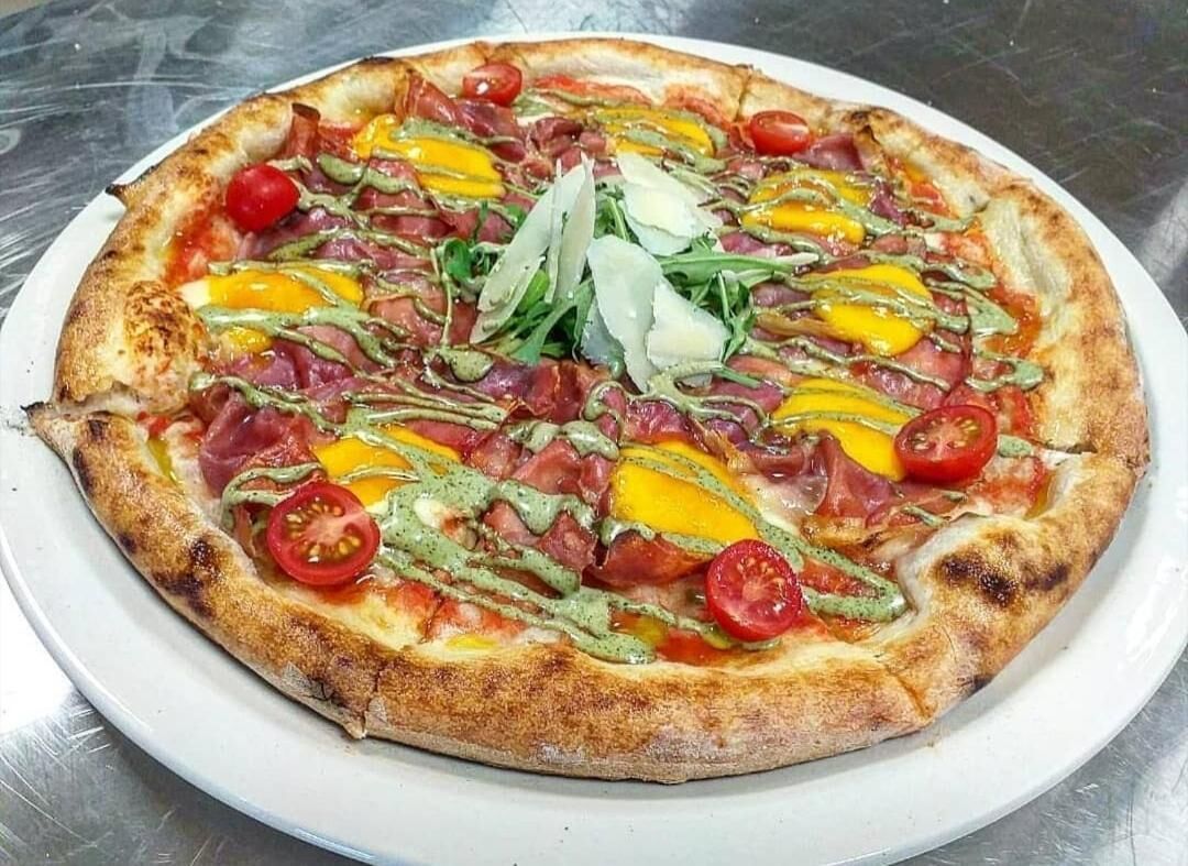 A pizza with various toppings on a white plate.