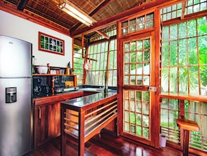 A kitchen with wooden cabinets, a stainless steel refrigerator, a sink, and a stove.