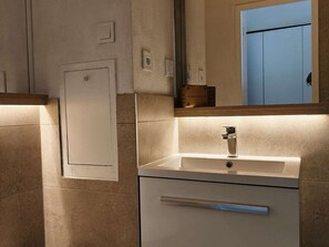 Ein Badezimmer mit Waschbecken, Spiegel und Tür.