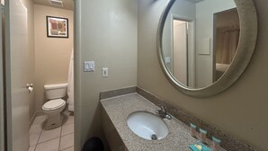 A bathroom with a toilet, sink, and mirror. - Happy Smart Inn I-10 Eloy and Casa Grande (Eloy)