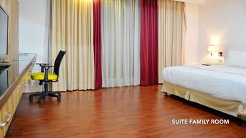 A suite family room with a bed, a desk with a chair, and a TV.