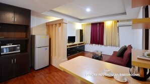A luxury penthouse with 2 bedrooms, featuring a kitchenette, a dining area, and a living room with a sofa and curtains. - Kasira Residence Serviced Apartment (South Tangerang)