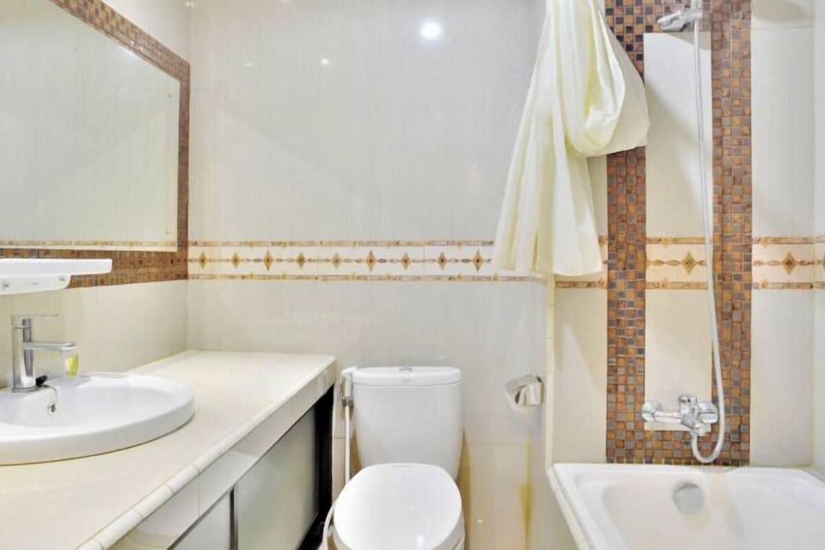 Un baño con lavamanos, inodoro y bañera.