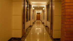 A hotel hallway with a shiny floor, walls with mirrors, and light fixtures on the ceiling. - Kasira Residence Serviced Apartment (South Tangerang)