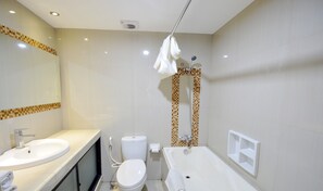 Bathroom features a sink, toilet, and bathtub with a showerhead, set against a checkered tile backdrop.
