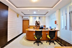Welcome to our reception area, featuring a curved desk, comfortable seating, and a beautiful sculpture.