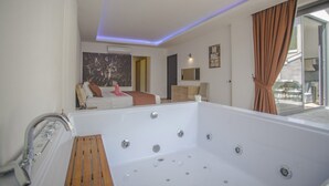 Ein modernes Badezimmer mit einer großen Badewanne, einer Duschkabine und einem Fenster mit Vorhängen.