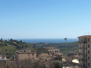 Un pueblo costero con edificios, cielo despejado y el mar al fondo.