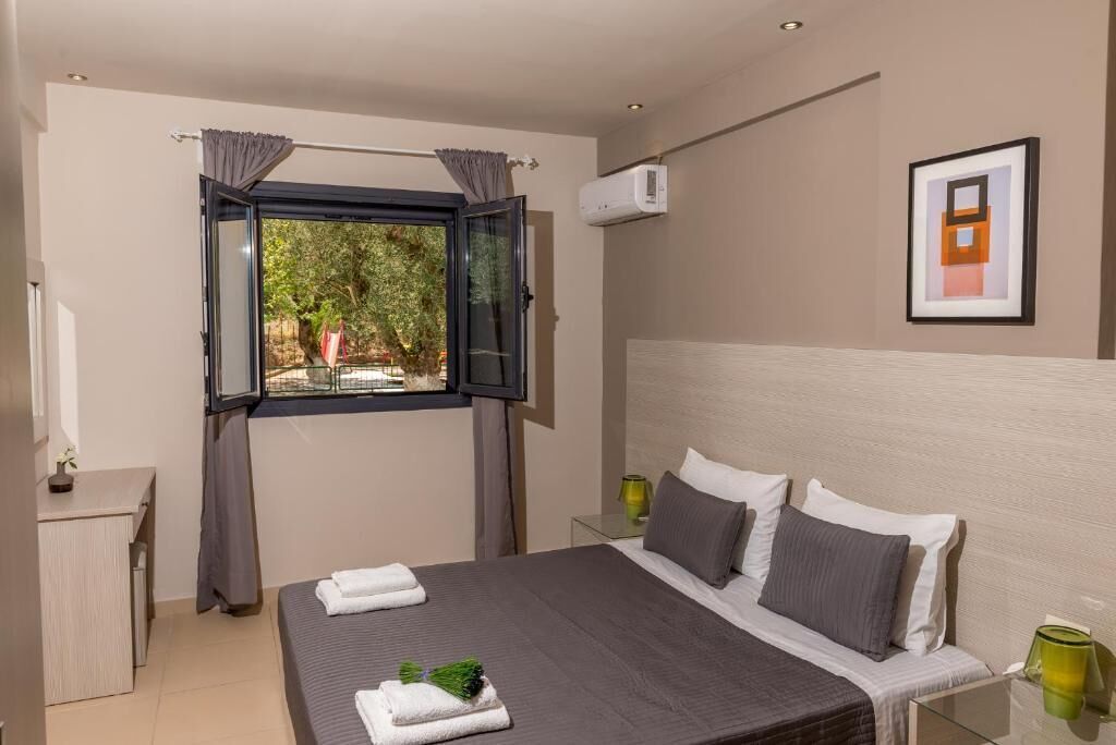 A modern bedroom with a bed, bedside tables, a desk, and a window with curtains.