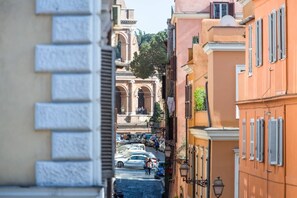 Una calle estrecha con coches aparcados y edificios a ambos lados.