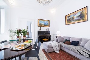 Una sala de estar con una mesa de comedor, sofá y un piano.