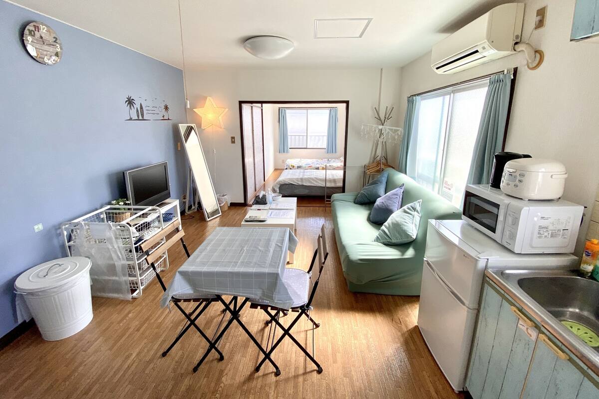 Un espacio habitable compacto con kitchenette, comedor y cama.