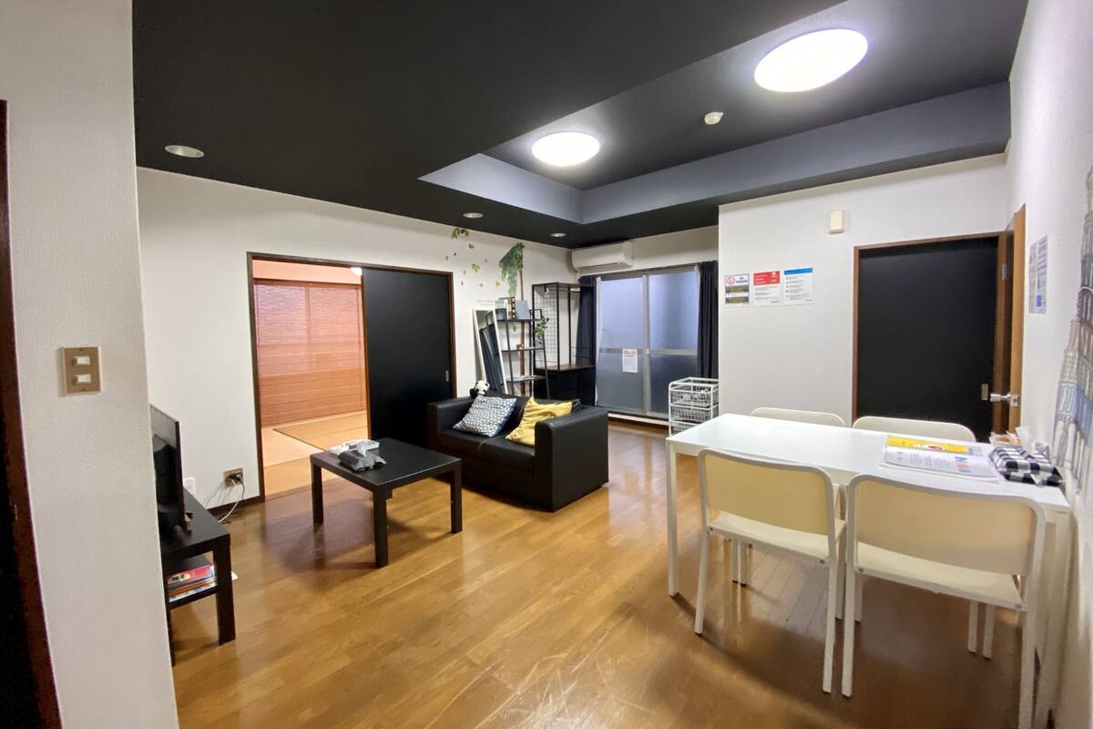 Un espacio habitable compacto con sofá, una mesa de comedor y un televisor pequeño.