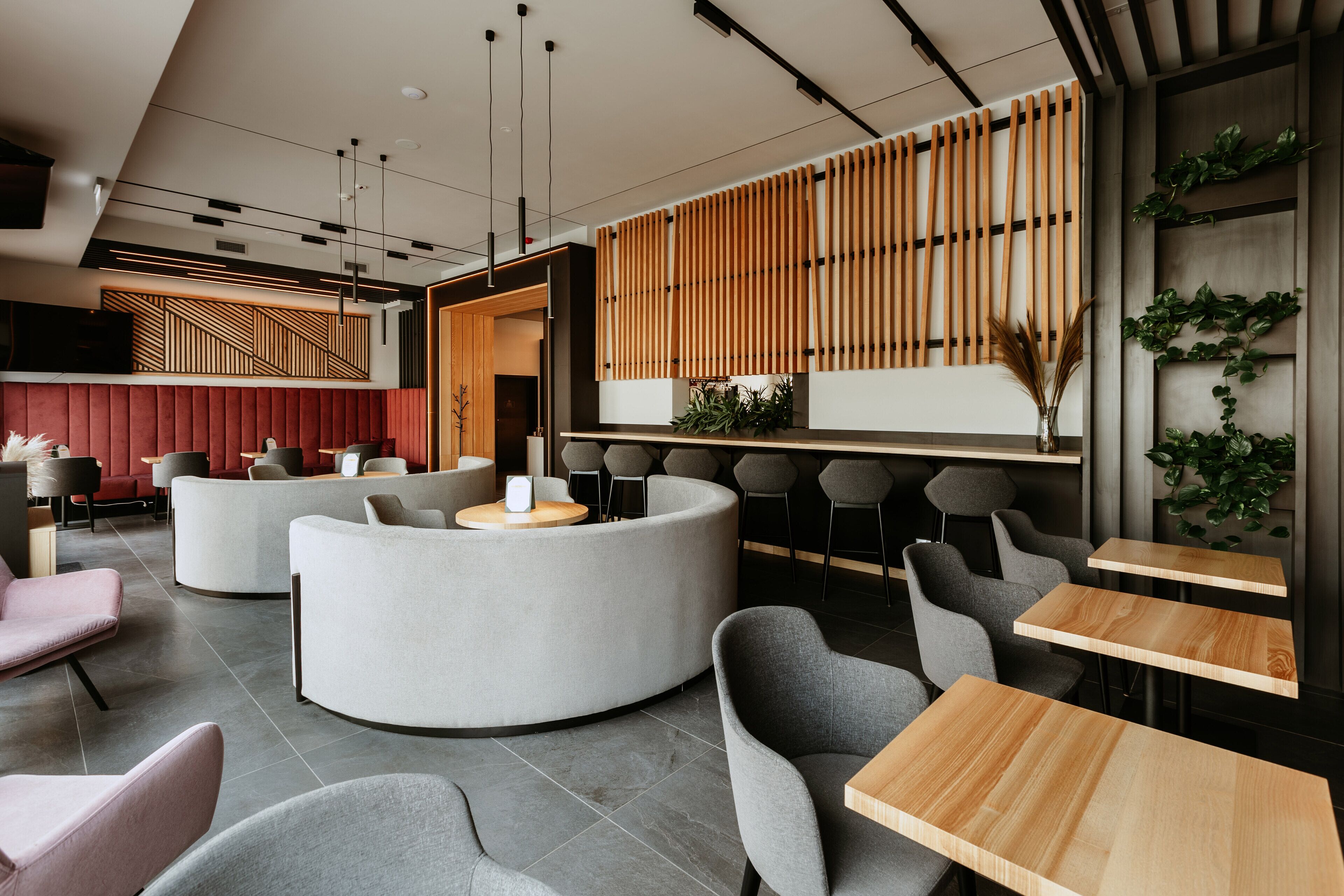 A modern interior with a reception desk, seating areas, and a wooden slat wall.