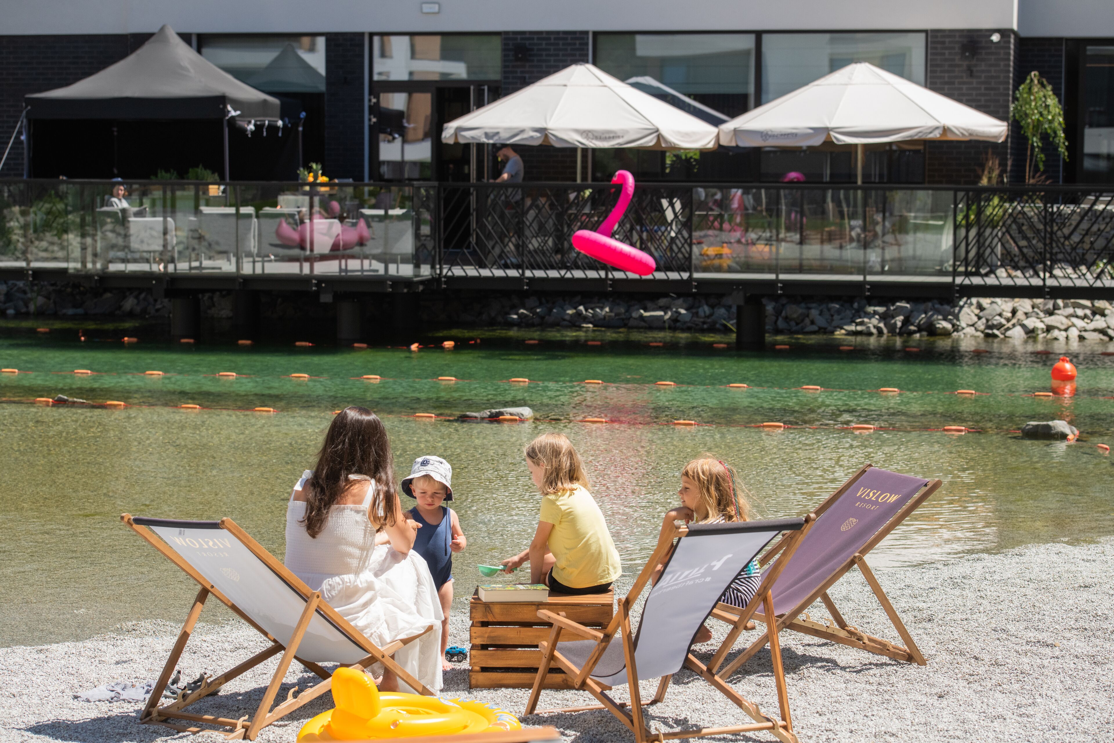 A pool area with lounge chairs and a dining area with umbrellas.