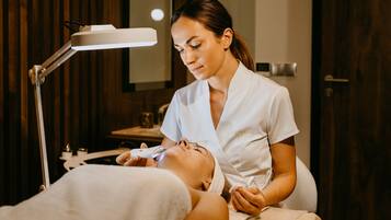 Eine Person liegt mit einem medizinischen Gerät im Gesicht, möglicherweise in einer medizinischen oder Wellnessumgebung.