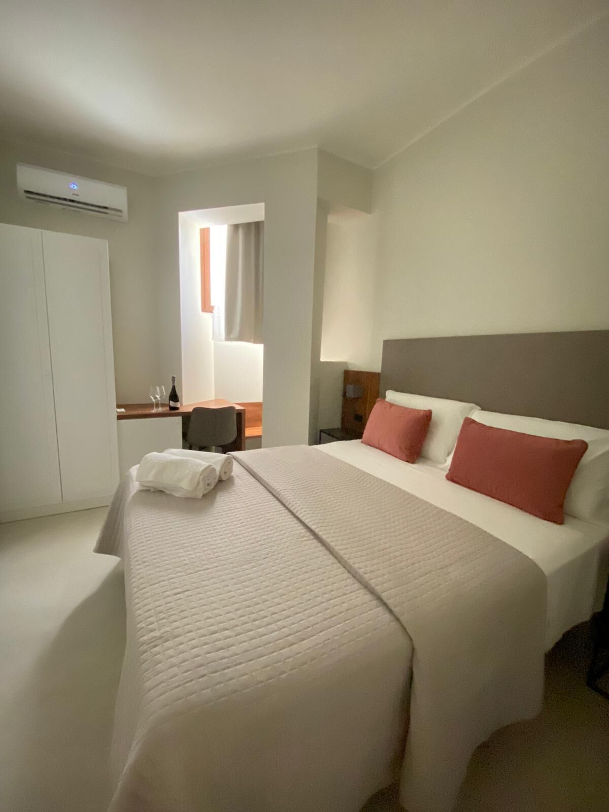 Ein Hotelzimmer mit einem großen Bett, einem Schreibtisch und einem Kleiderschrank.