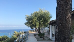 A pathway leading to a building with a view of the sea. - Hotel Marina del Capo (Ricadi)