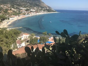 Un borgo costiero con spiaggia, case e vista chiara sul mare.